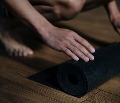 Empty yoga mat on a wooden floor, ready for practice.